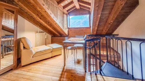 a living room with a table and a couch and a window at Casa Loca Colere in Colere