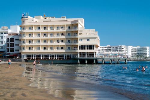un hotel en la playa con gente en el agua en Hotel Médano en El Médano
