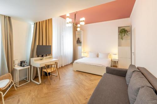 a living room with a bed and a desk with a tv at Midi Inn Parkhotel Mitte in Berlin