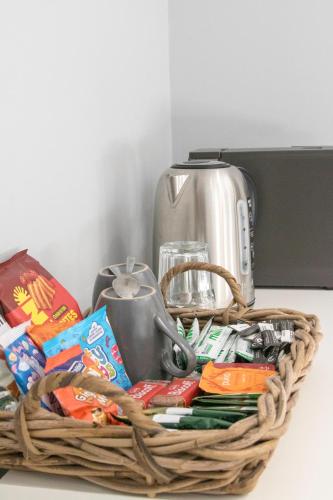 a basket filled with food and a toaster on a counter at The Southport Seaside Snug Suites in Southport
