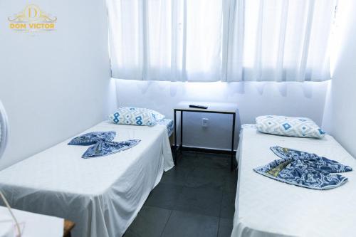 two beds sitting next to each other in a room at Dom Victor Residence Hotel in Goiânia