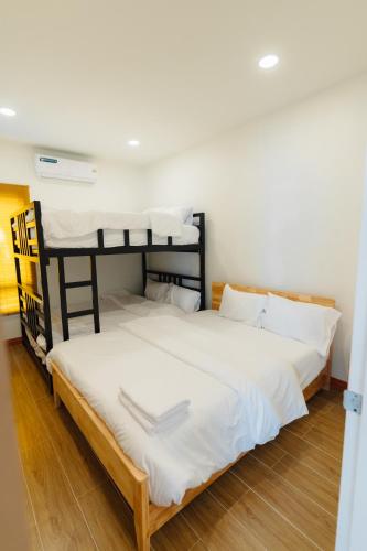 two bunk beds in a room with wood floors at Tenki poolvilla srisaket in Ban Phia Nam