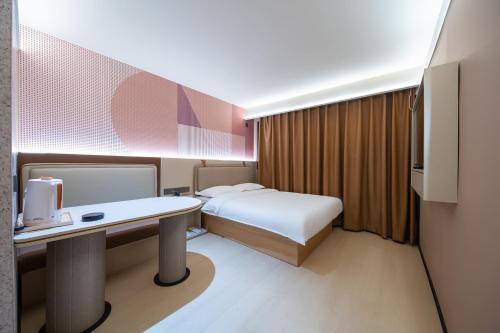 a hotel room with a bed and a desk with a computer at Zhuoya Garden Hotel in Beijing