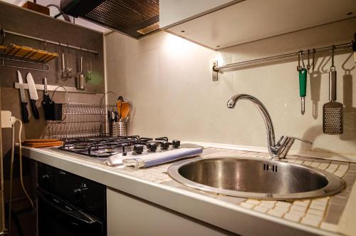 a kitchen counter with a sink and a stove at Medieval central apartment in Bologna