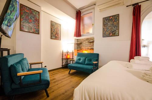 a bedroom with two blue chairs and a bed at Medieval central apartment in Bologna