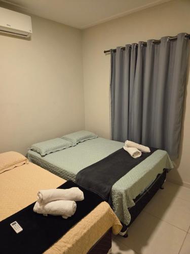 a bedroom with two beds with towels on them at Casa aconchegante e estruturada in Bragança