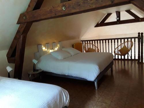 a bedroom with two beds and two chairs at Gîte with pool & Nordic bath in Monthois