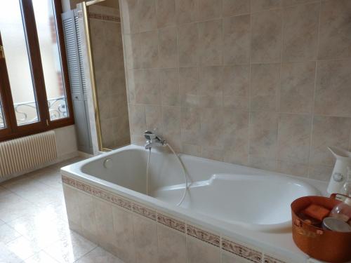 a bath tub with a faucet in a bathroom at Gîte with pool & Nordic bath in Monthois