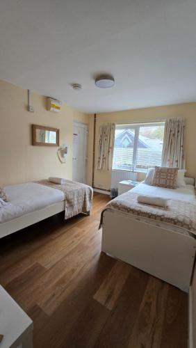a bedroom with two beds and a large window at Snowdonia Mountain Lodge in Bethesda