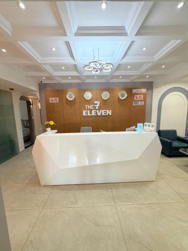 a lobby with a white reception desk in a building at The 7 elevan hotel in Sānand