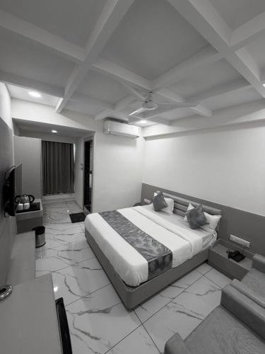 a bedroom with a large bed in a white room at The 7 elevan hotel in Sānand