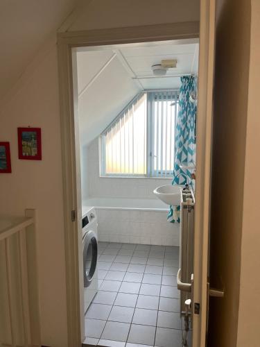 a bathroom with a toilet and a sink and a window at Ark in Terherne