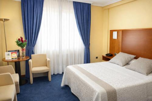 a hotel room with a bed and a window at Motel Punta Cana in Santiago de Compostela