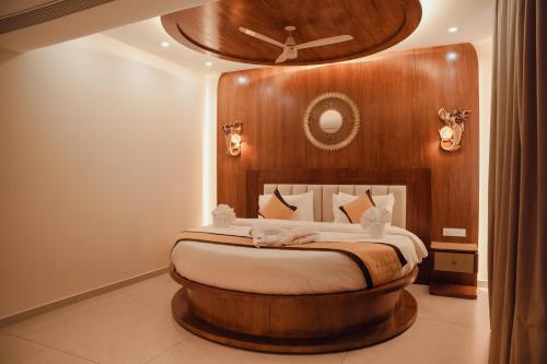 a bedroom with a large bed with a wooden headboard at Green View Suites in Kalyānpur