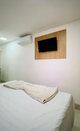 a bedroom with a bed with a tv on the wall at Giacomelli Plaza Hotel in Rio Verde