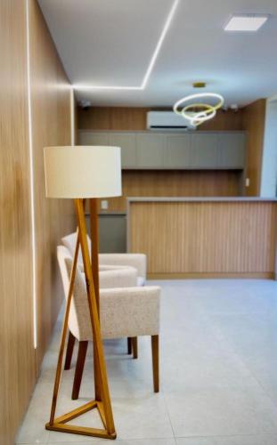 a room with a chair and a table and a lamp at Giacomelli Plaza Hotel in Rio Verde