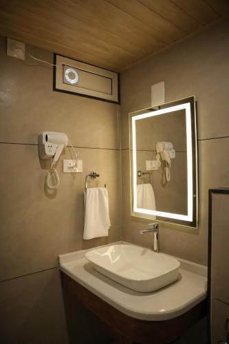 a bathroom with a sink and a mirror at Green View Suites in Kalyānpur