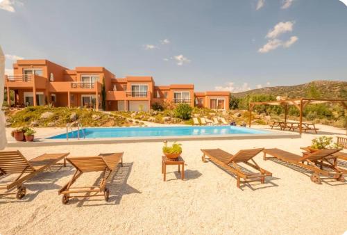 a villa with a pool and chairs and a resort at Little Eden Homes in Agios Nikolaos