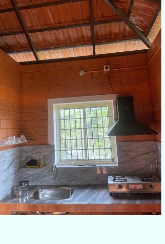 a kitchen with a sink and a window at Alloos homestay villa in Attappādi