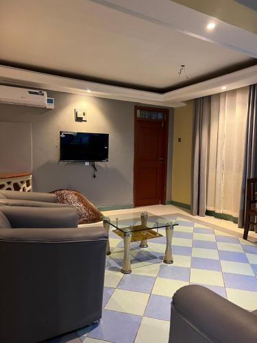 a living room with a couch and a tv at Capri Hills 4 in Mwanza