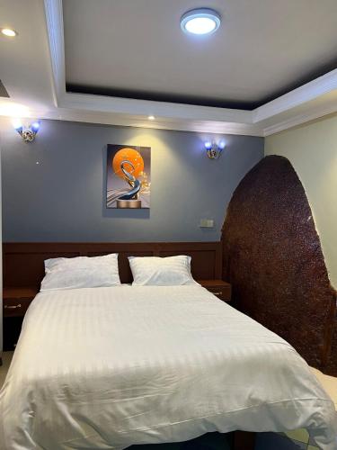 a bedroom with a large bed with white sheets at Capri Hills 4 in Mwanza