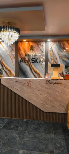 a counter in a restaurant with a painting on the wall at Hotel Alaska in Patna