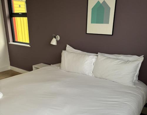 a bed with white sheets and pillows in a bedroom at Pennan - 2 Bed Luxury Apartment by Together Travel in Wick