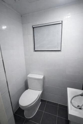 a white bathroom with a toilet and a sink at The loft 6 in Busan