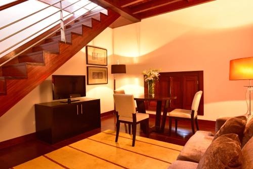a living room with a couch and a table with a television at Pousada Convento de Tavira in Tavira