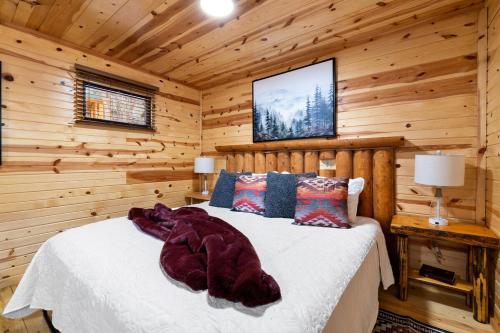 a bedroom with a bed in a log cabin at Bison Trail House- Rustic Cabin Retreat in Rapid City