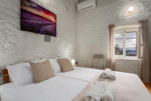 a bedroom with a white bed with towels on it at Casa Lampadina in Vižinada