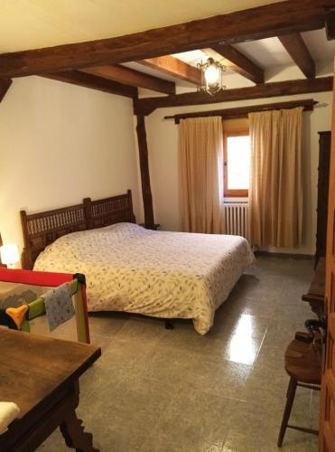 a bedroom with a bed and a table and a window at Casa Rural Las Mieles in Chillarón del Rey