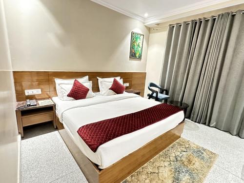 a hotel room with a large bed and a desk at Shree Vatika in Rishīkesh