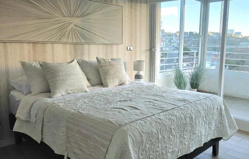 a bedroom with a large bed with a large window at Gran espacio para descansar cerca de todo in Concón
