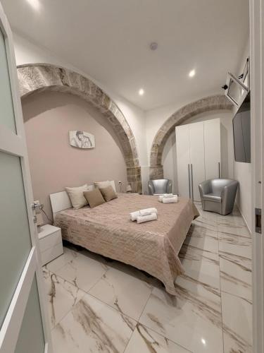 a bedroom with a large bed and two chairs at B&B Heracleae Luxury Home in Cattolica Eraclea
