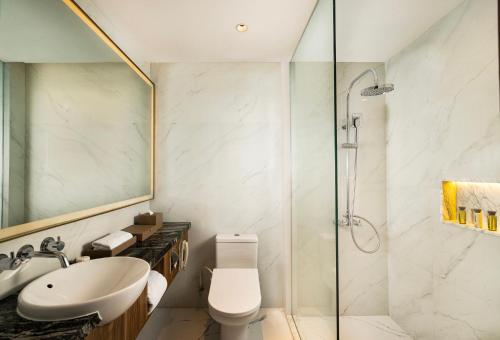 a bathroom with a sink toilet and a shower at Royal Ambarrukmo Yogyakarta in Yogyakarta