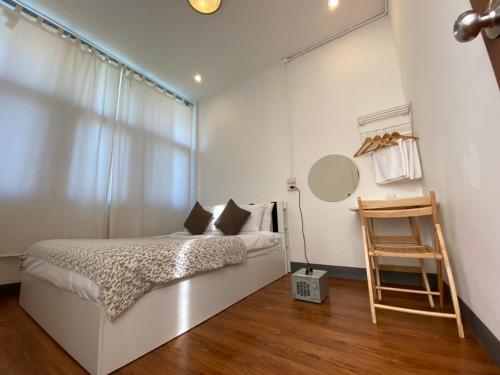 a white bedroom with a bed and a window at Allrange Home 5 bedroom for 10 guests in Chiang Mai