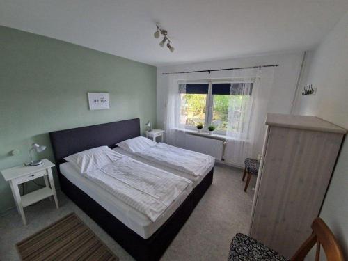 a bedroom with a large bed and a window at Rotbuche in Ruhwinkel
