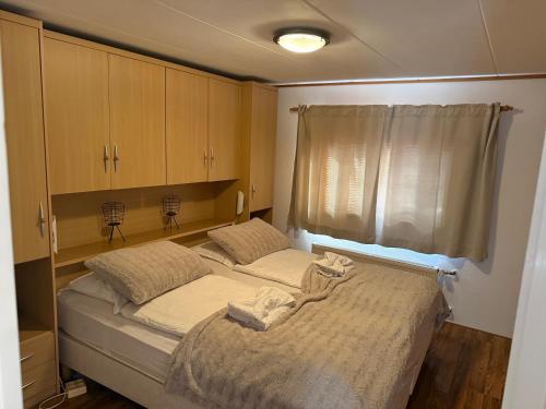 a bedroom with a large bed with a window at Chalet Makkum V10 in Makkum