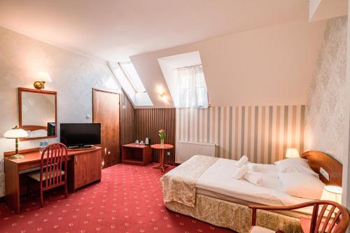 a hotel room with a bed and a television at Hotel Restauracja Browar Lwów w Lublinie in Lublin