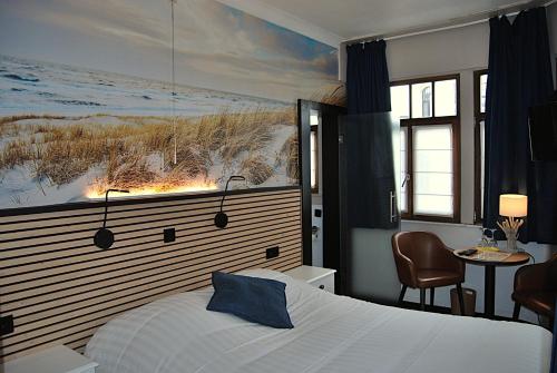 a bedroom with a bed and a painting on the wall at Hotel Montana in De Panne