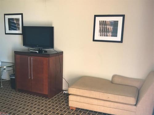 - un salon avec un canapé et une télévision sur une armoire dans l'établissement Grantmoor Motor Lodge, à Newington
