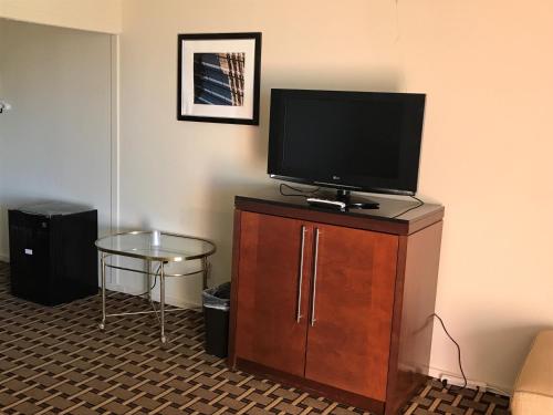 un téléviseur à écran plat posé sur un meuble en bois dans l'établissement Grantmoor Motor Lodge, à Newington