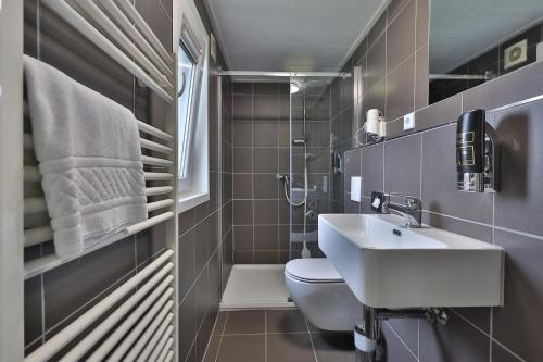 a small bathroom with a sink and a toilet at M13 Hotel in Riol
