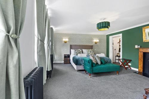 a bedroom with a bed and a green couch at The Drawing Room at The Merchants in Berwick-Upon-Tweed