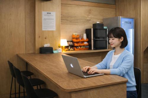 a woman sitting at a counter using a laptop computer at The loft 6 in Busan