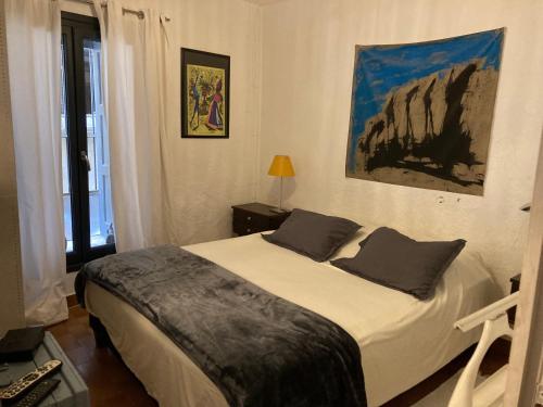 a bedroom with a bed and a painting on the wall at La suite Galerie d'ART in Céret