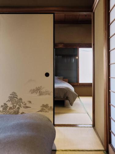 a bedroom with a glass door leading to a bed at CraftFlat Asakusa House, Space to Live, Laugh, and Feel at Home in Tokyo