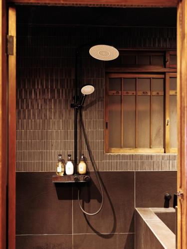a shower in the corner of a bathroom at CraftFlat Asakusa House, Space to Live, Laugh, and Feel at Home in Tokyo