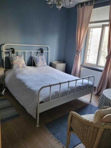 B&B Sparrow's Nest في خنت: غرفة نوم بها سرير وكرسي ونافذة